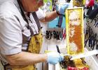 This beekeeper is slicing open the wax caps on the cells of honey with a hot knife. How do Beekeepers harvest beeswax?