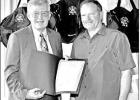 GAZETTE PHOTO / ELLIS KNOX Pittsburg Mayor David Abernathy presents a proclamation to Mike Reynolds, director of Camp County Emergency Medical Services at a 40th anniversary celebration of the ambulance service May 23. The two men and their fathers were i Article Image Alt Text