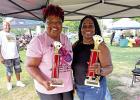 Keshia Douglas and Vernita Castleberry holding their trophies as first place winners in the Juneteenth celebration card tournament