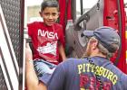 Daniel Perez climbs out of the fire truck on his way to some ice cream. Because his mom is a security guard for the school, and his father is in EMS, Daniel has now ridden in at least three different types of first-responder vehicles. GAZETTE PHOTO / ELIZ Flashy ride to a cool treat for some hot kids