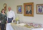 Vee Couch, owner, and Kimberly Mercer, secretary, beside portraits of the Couch family. GAZETTE PHOTO / KELSIE HOOPER Pittsburg Insurance celebrates 100th year anniversary