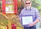 GAZETTE PHOTO / ELIZABETH LANNING Bryan Freisth stands near the new Little Free Library. The books are available for one and all. Ribbon cutting takes