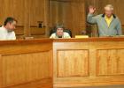 Gazette photo/LYNDA STRINGER PISD Board President Jack Arnwine, right, and Board Member Christian Yantis, left, raise their hands to vote in favor of accepting PISD Superintendent Judy Pollan's decision to retire while Pollan looks on. Article Image Alt Text