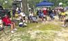 Juneteenth celebrators gather in tents and under trees, barbecuing, playing cards, listening to music, enjoying the company